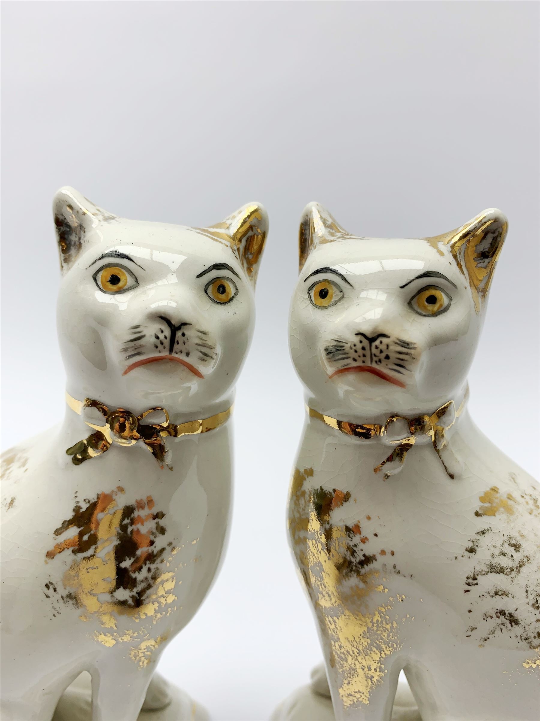 Pair of Victorian Staffordshire cats, modelled seated upon cushions, with gilt detail throughout, H18cm