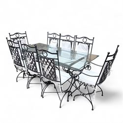 Wrought steel rectangular conservatory dining table, with glass top; and six, four side and two armchairs, with lattice backs and X framed bases, loose cushions