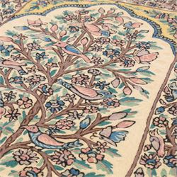 Kashmiri chain stitch crewel embroidered wall hanging, the tree of life design embroidered on a cream ground with coloured pastel tones of rose, teal blue, and light brown in an arched mihrab style framing 