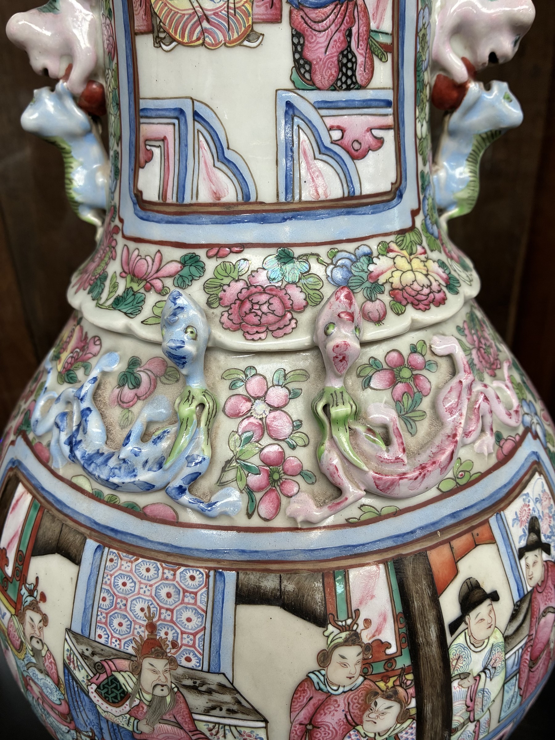 Large pair of 19th century Cantonese famille rose vases, each painted with various courtly scenes, including a display of warriors fighting on horseback before an official and his attendants, double Buddhist lion handles and applied at the shoulders with chilong, the lower band painted with Greek key motif, H58cm (2)