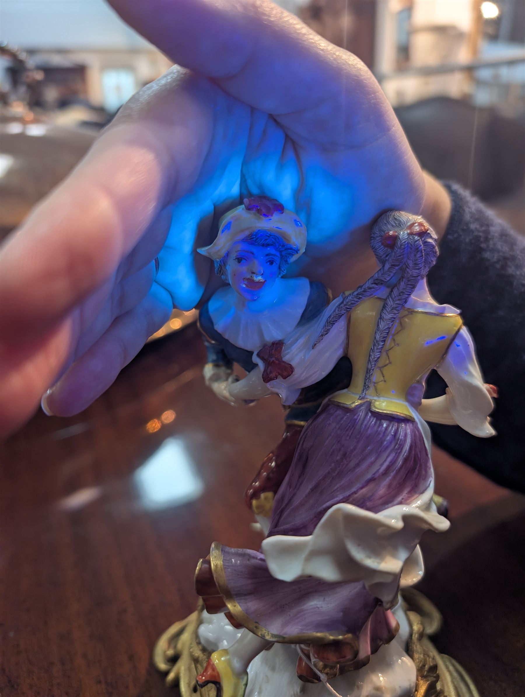 Mid 18th century Meissen figure group, The Tyrolean Dancers, circa 1740, modelled as two swirling figures with their arms linked, he in yellow hat with red rosette, blue jacket, red breeches with red rosette, and yellow shoes with green rosette, she in white blouse with red ribbons, yellow and red bodice, white apron over puce skirt and yellow shoes with green rosettes, her hair fashioned into two plaits secured by red ribbon, upon a shaped mound base, within a scrolling gilt metal mount, with blue crossed swords mark to base, overall H19cm
