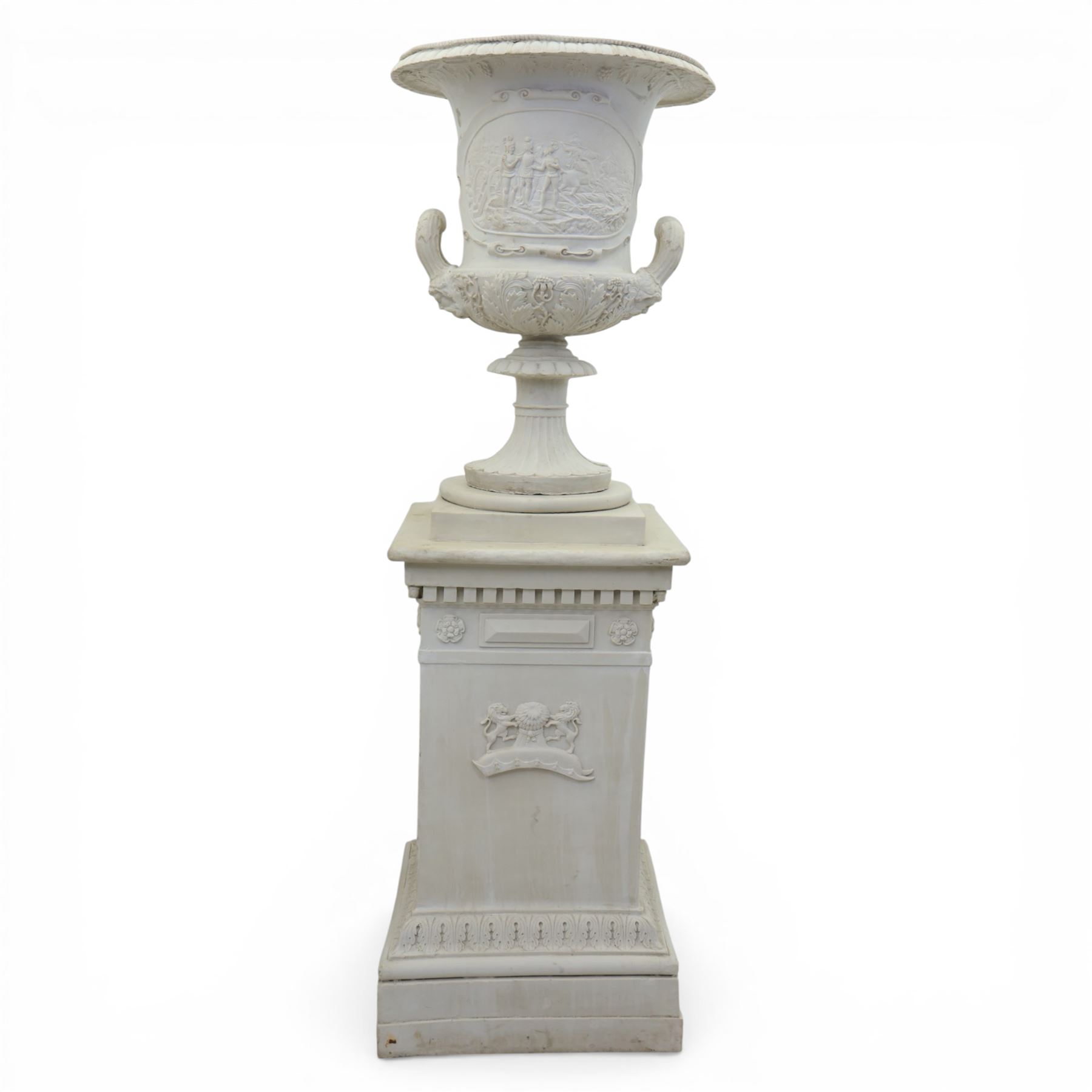 Pair of composite campana urns on stands, the urns decorated with relief figural panels and foliate bands with scrolling handles, on circular socles, the pedestals of square tapering form with moulded edges and applied classical motifs