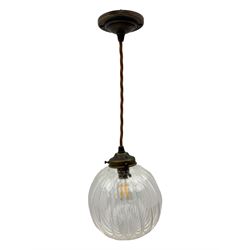 Set of two small and two large pendant lights, each with clear glass spherical shade with moulded swirl pattern, suspended from twisted cords, brass ceiling rose