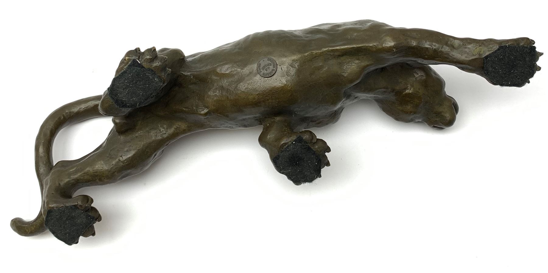 A bronze figure, modelled as a cougar in crouching pose, signed Milo and with foundry mark, L40cm.
