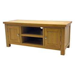 Contemporary oak television stand, rectangular top over two central open compartments, flanked by panelled cupboard doors enclosing additional shelves, raised on stile supports