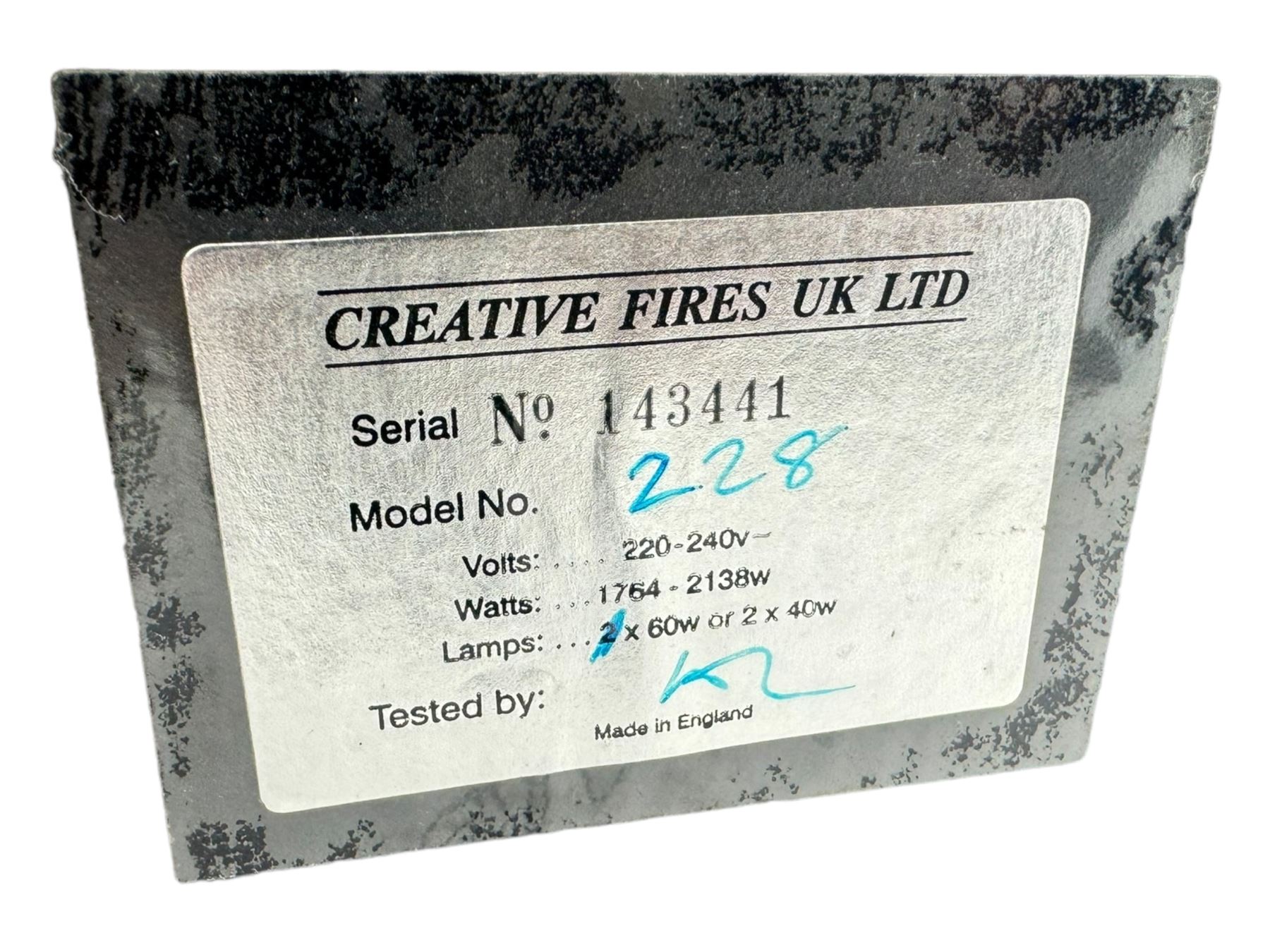 Stained glass and cast iron electric fireplace, arched top with decorative finials, stained glass front panel with floral motifs, flanked by cast iron scrolls, raised on scroll supports