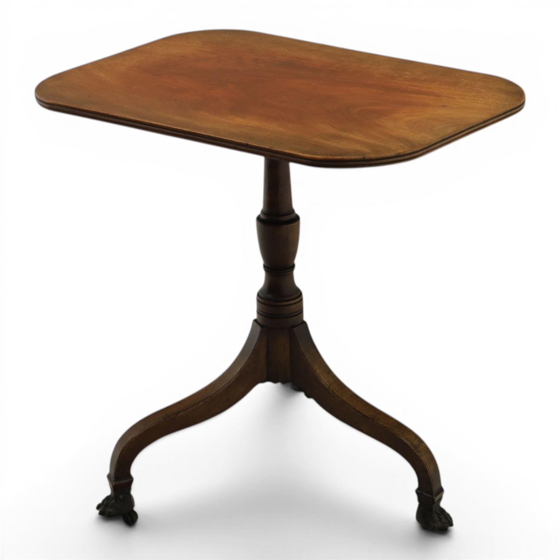 George III mahogany tripod table, rounded rectangular tilt top, raised on a turned column, on splayed supports, terminating brass claw feet above castors