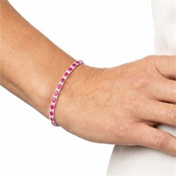 18ct white gold ruby and diamond bracelet, twenty-six oval cut rubies, each spaced by two round brilliant cut diamonds, hallmarked, total ruby weight approx 9.40 carat, total diamond weight 0.50 carat
