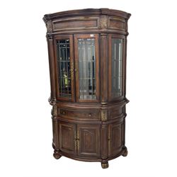  Kevin Charles American walnut demi lune display cabinet with illuminated interior, projecting cornice, two bevel edge glazed doors enclosing two adjustable shelves above single drawer and four cupboard doors with wine rack, carved scrolling supports