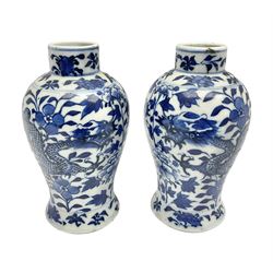  Pair of late 19th/early 20th century Chinese blue and white vases, each of baluster form, painted with dragons amidst flowers, each with Kangxi character marks beneath, H14cm 