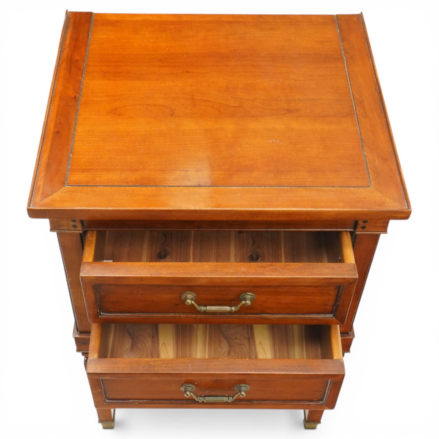 Willis & Gambier - pair of 'Directoire' cherry wood bedside tables, rectangular top with cock-beaded edge over two panelled facia drawers, raised on square turned and tapering supports on brass feet