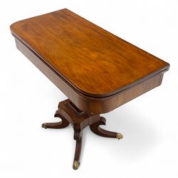 Regency mahogany fold-over table, hinged top with rounded corners opening to reveal a plain polished surface, supported on moulded pedestal base with reeded downswept legs, terminating in brass cups and castors (Extends to 90cm)