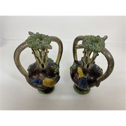 Pair of 19th century Portuguese Palissy style Majolica puzzle jugs, attributed to Manuel Mafra, with mossy rim and pierced lattice neck, twin handles in the form of snakes and the body decorated with frogs, lizards, and moths on a mottled brown glazed ground, unmarked, H20cm
