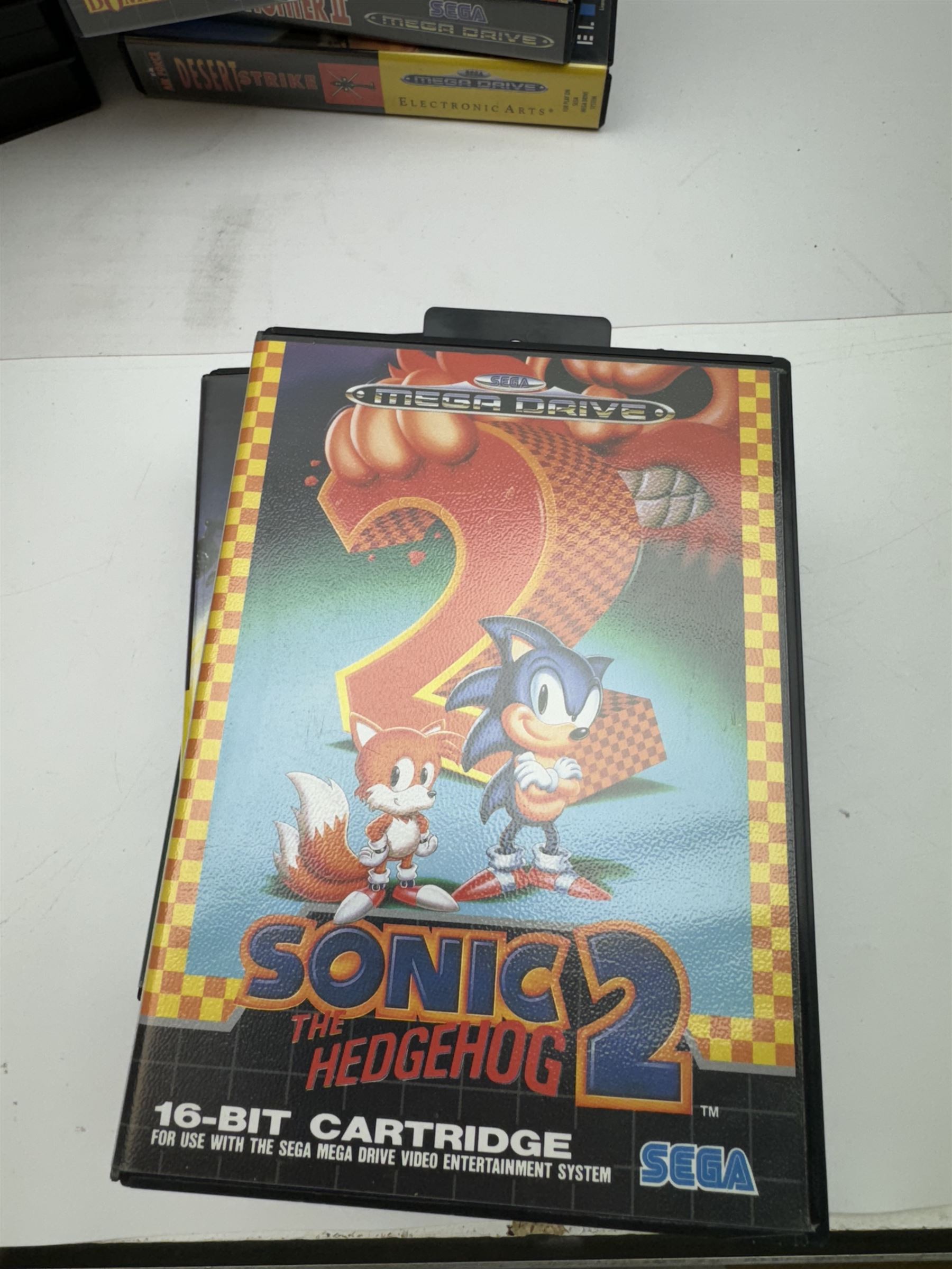 Eighteen Sega Mega Drive games, including Sonic The Hedgehog, Sonic The Hedgehog 2, Alienstorm, Desert Strike, Fatal Rewind, Road Rash etc, all boxed, together with a Sega Mega Drive controller, cartridge converter and an arcade power stick controller