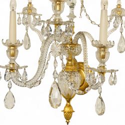 Pair of George III ormolu and cut-glass wall-lights, each with a tall central urn-shaped finial above a series of faceted glass spires and scrolled branches, the ormolu-mounted nozzles and drip pans hung with festoons of cut-glass drops and pear-shaped pendants, the lower section centred by a pineapple finial, wired for electricity