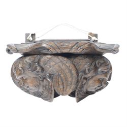 17th century carved oak wall bracket, modelled as two well carved winged putto masks, supp...