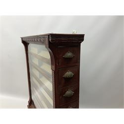 Late Victorian wall mounting cigarette case or display cabinet, the cornice with repeating oval guilloche decoration, ribbed uprights enclosing glazed window, fitted with seven sliding drawers with divisions and mounting blocks, in red finish, inscribed verso. 