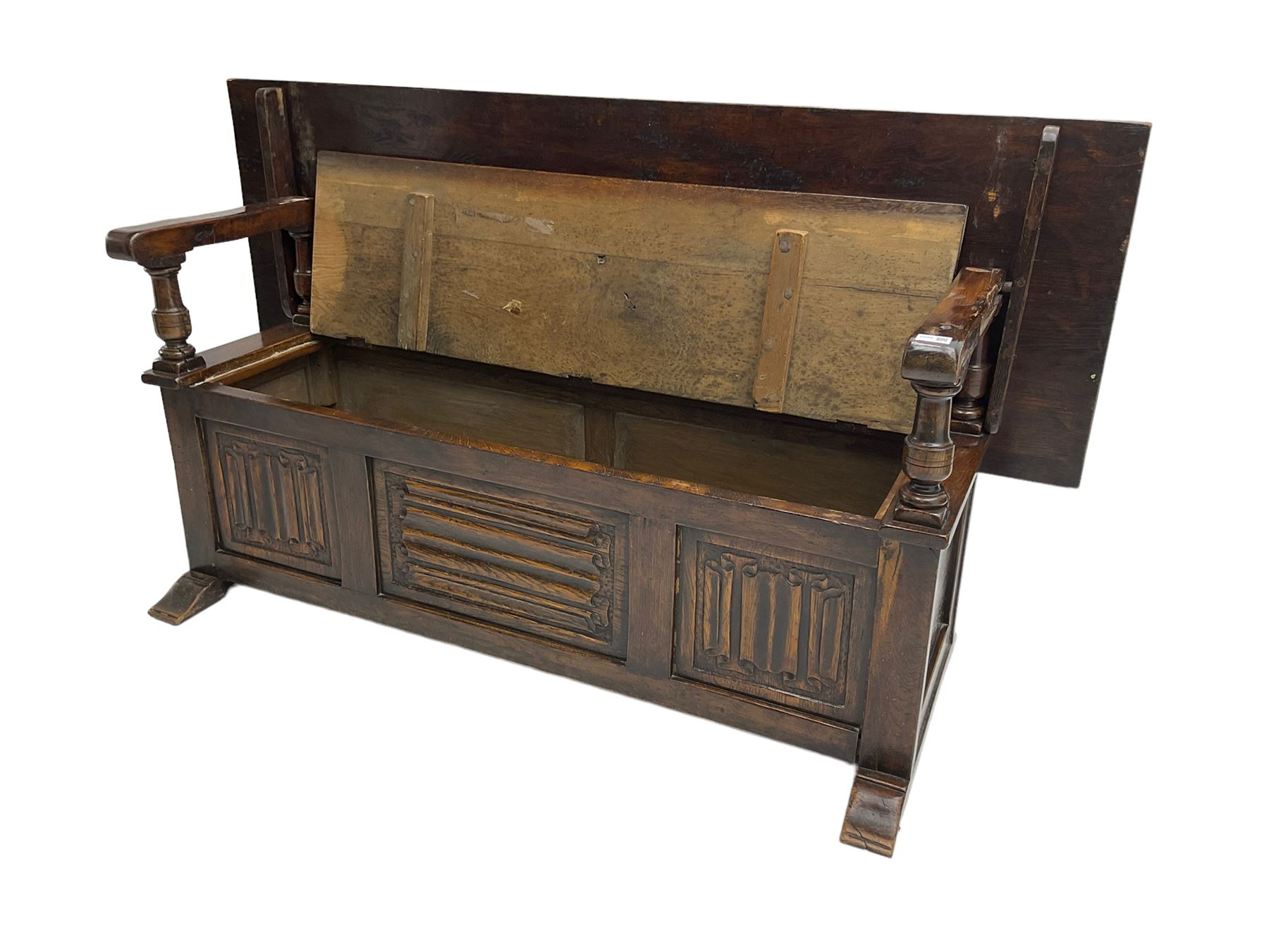 Jacobean design oak Monks bench, the front with carved linenfold panels, hinged metaphoric table back, hinged box seat compartment, on sledge feet