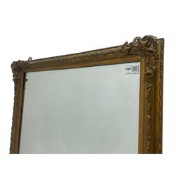 19th century gilt framed wall mirror, the corners decorated with flower heads with extending foliage, plain mirror plate