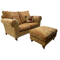 Duresta two seat sofa, upholstered in pale gold and rose fabric, mahogany feet; and matching rectangular footstool