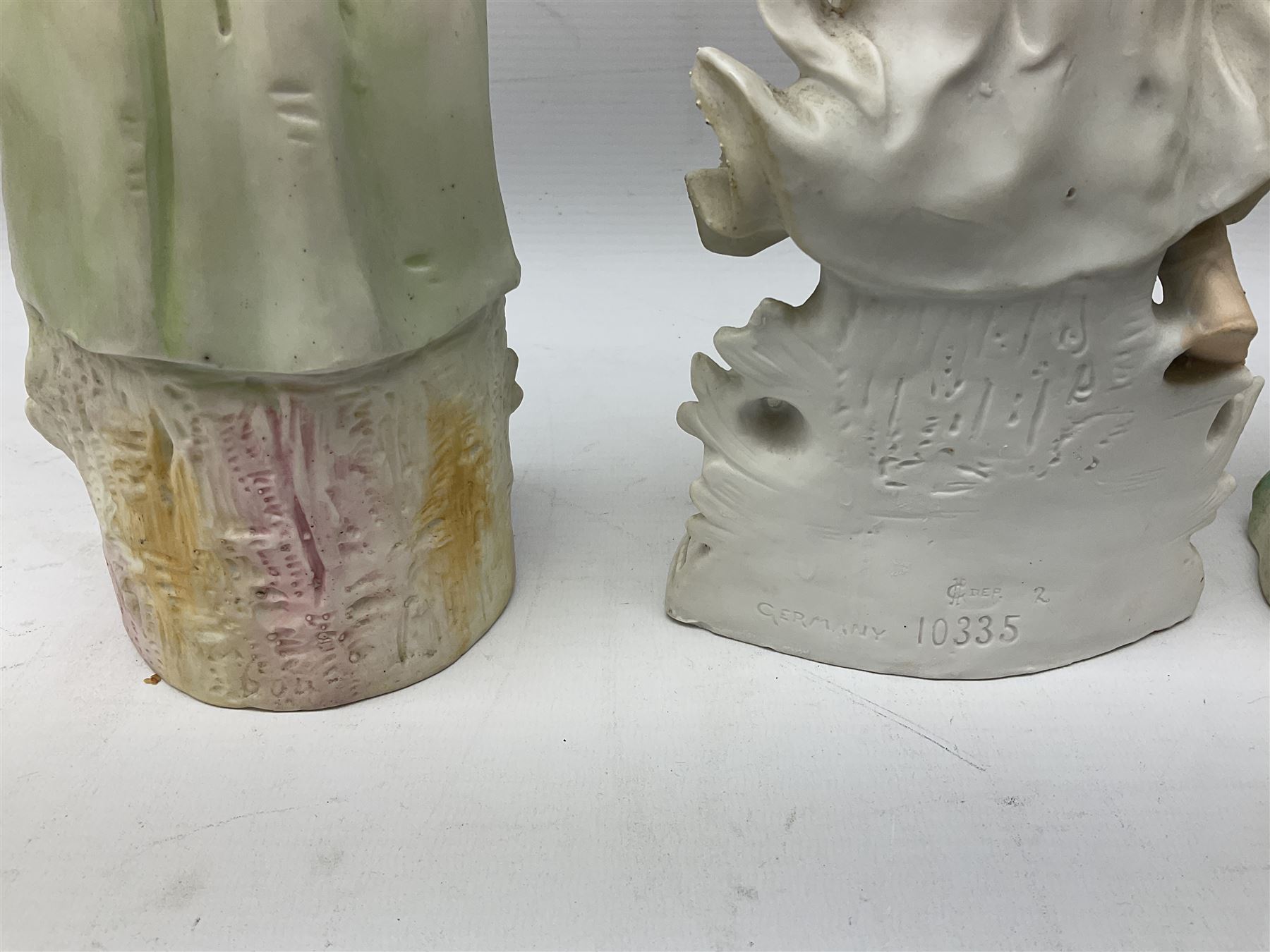 Late 19th century continental spill vase as a young girl standing beside an open tree trunk H21cm; and three German bisque figures (4)