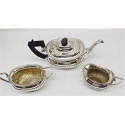 Victorian three piece silver tea service, comprising teapot with ebonised handle and finial, twin handled open sucrier, and milk jug, each of oval part fluted form with oblique gadrooned rim, hallmarked George Nathan & Ridley Hayes, Chester 1896, approximate gross weight 34.22 ozt (1064.6 grams)