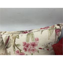 Five scatter cushions, two with floral decoration and three red, etc