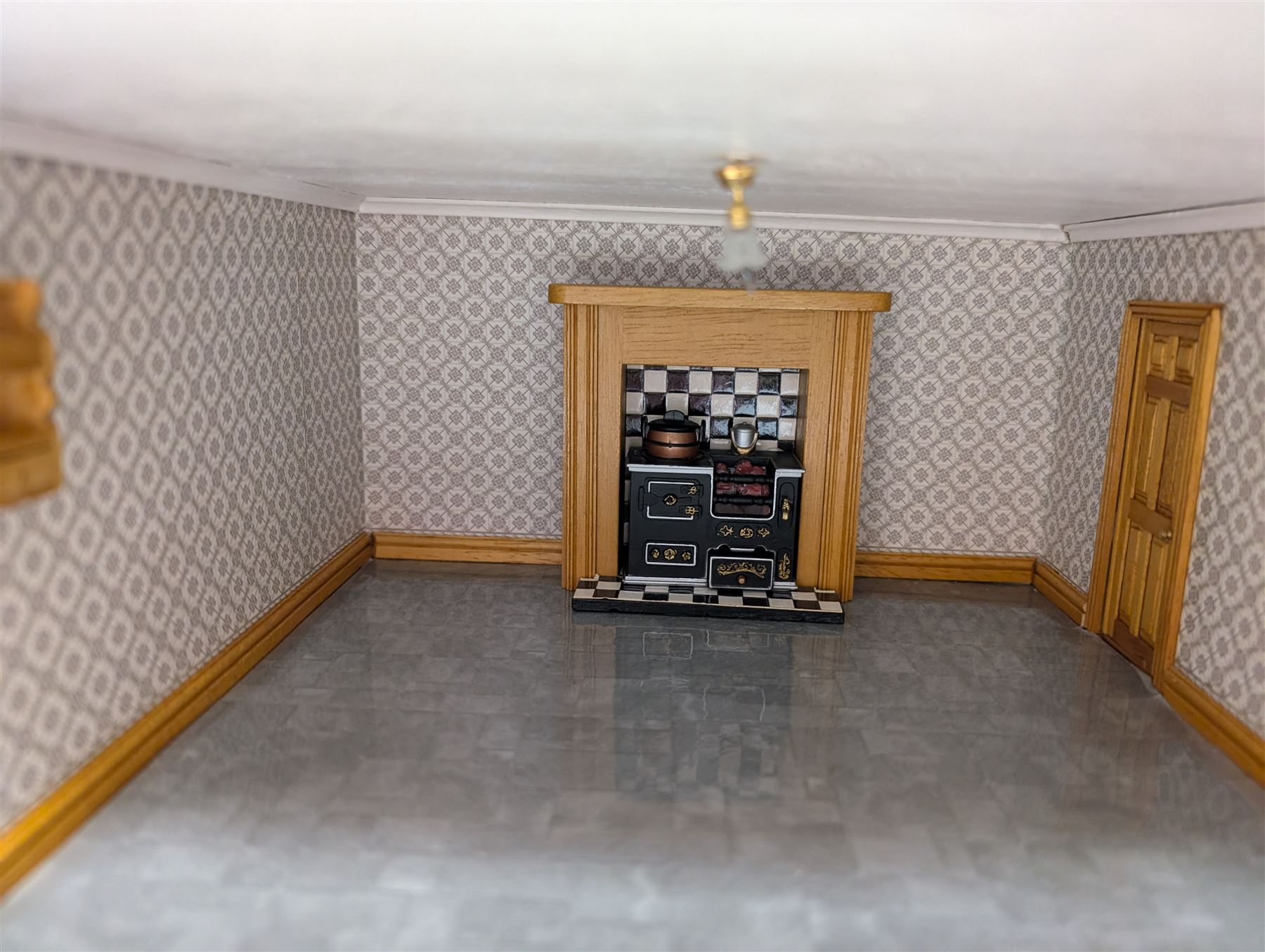 1:24 scale four-storey tudor-style dolls house, with black and white exterior, balcony garden, glazed panelled windows and wooden shingle roof, with decorated interior and wired fireplaces and lighting, H65cm, W58cm, D31cm, 