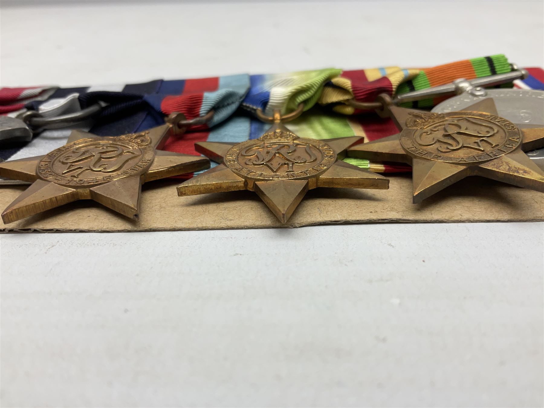 WW2 Royal Naval group of eight medals comprising OBE, hallmarked silver Distinguished Service Cross inscribed verso Lieut. J.R. McCluskie RNVR 1945, 1939-1945 Star, Atlantic Star, Africa Star, 1939-1945 War Medal, Defence Medal and Royal Naval Patrol Service Medal inscribed Lieutenant J.R. McCluskie Royal Naval Patrol Service; with seven original photographs of a sea battle 27th November 1940 against the Italian Fleet and another photographic postcard of Sir Stafford Cripps arriving on board one of the vessels.