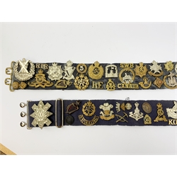 Collection of Glengarry and cap badges, shoulder titles, collar dogs, buttons etc mounted on two military belts, including rare Kitchener's Army Volunteer Training Corps Surrey 1915, two Ulster Volunteer Force (L6521 & L2007), Royal Irish, North Irish Horse, Inniskillings, Royal Irish Rifles, London Irish, London Irish Rifles, Royal Irish Fusiliers, Queen's Own Cameron Highlanders, Royal Scots, 9th Battalion (Glasgow) HLI, Royal Welch Fusiliers, South Wales Borderers, Church Lads Brigade, various regiments and corps, RUC and officer's training corps buttons etc
