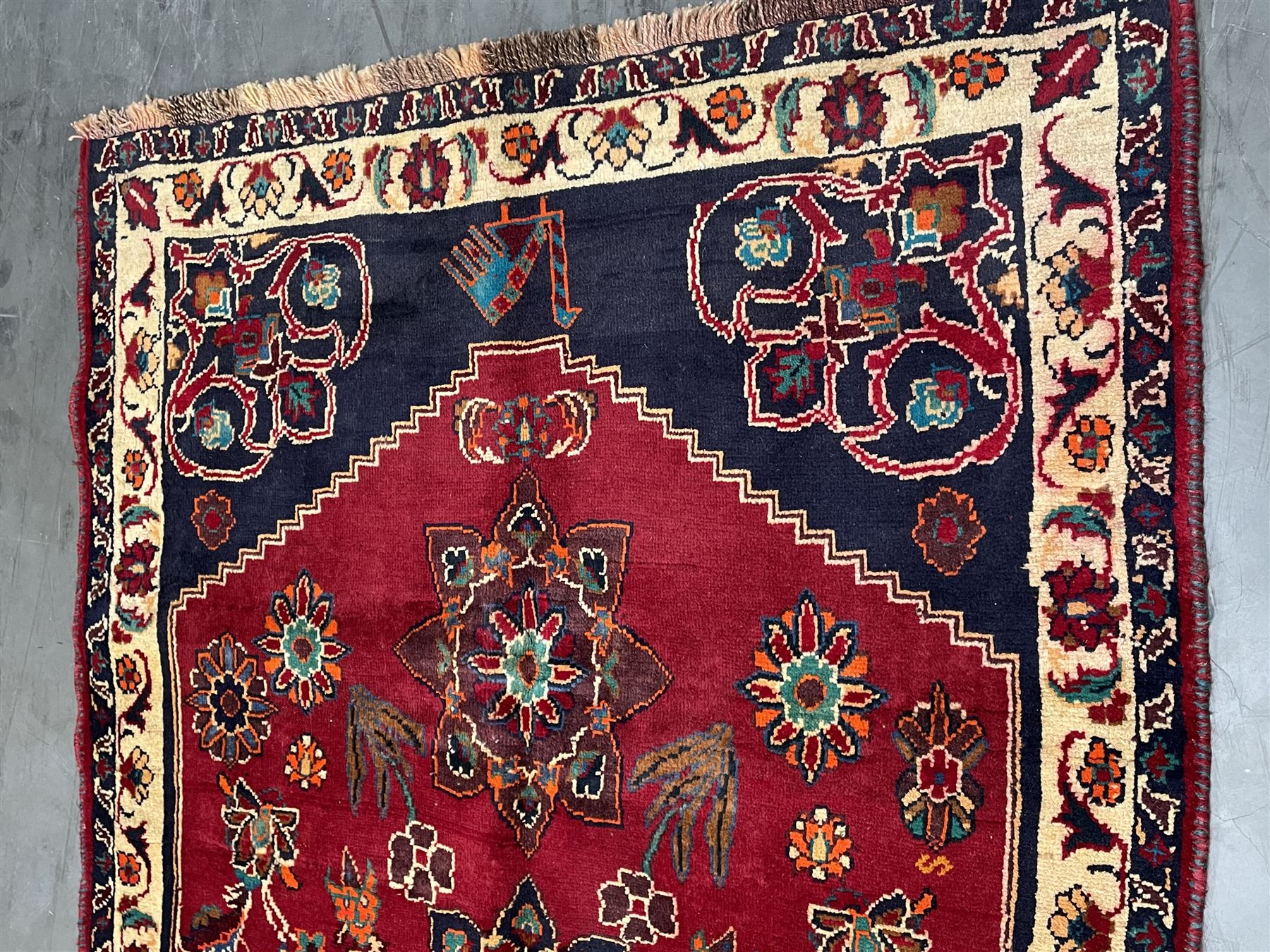 Persian rug, red ground field decorated with stylised flower heads and bird motifs, floral scrolling border