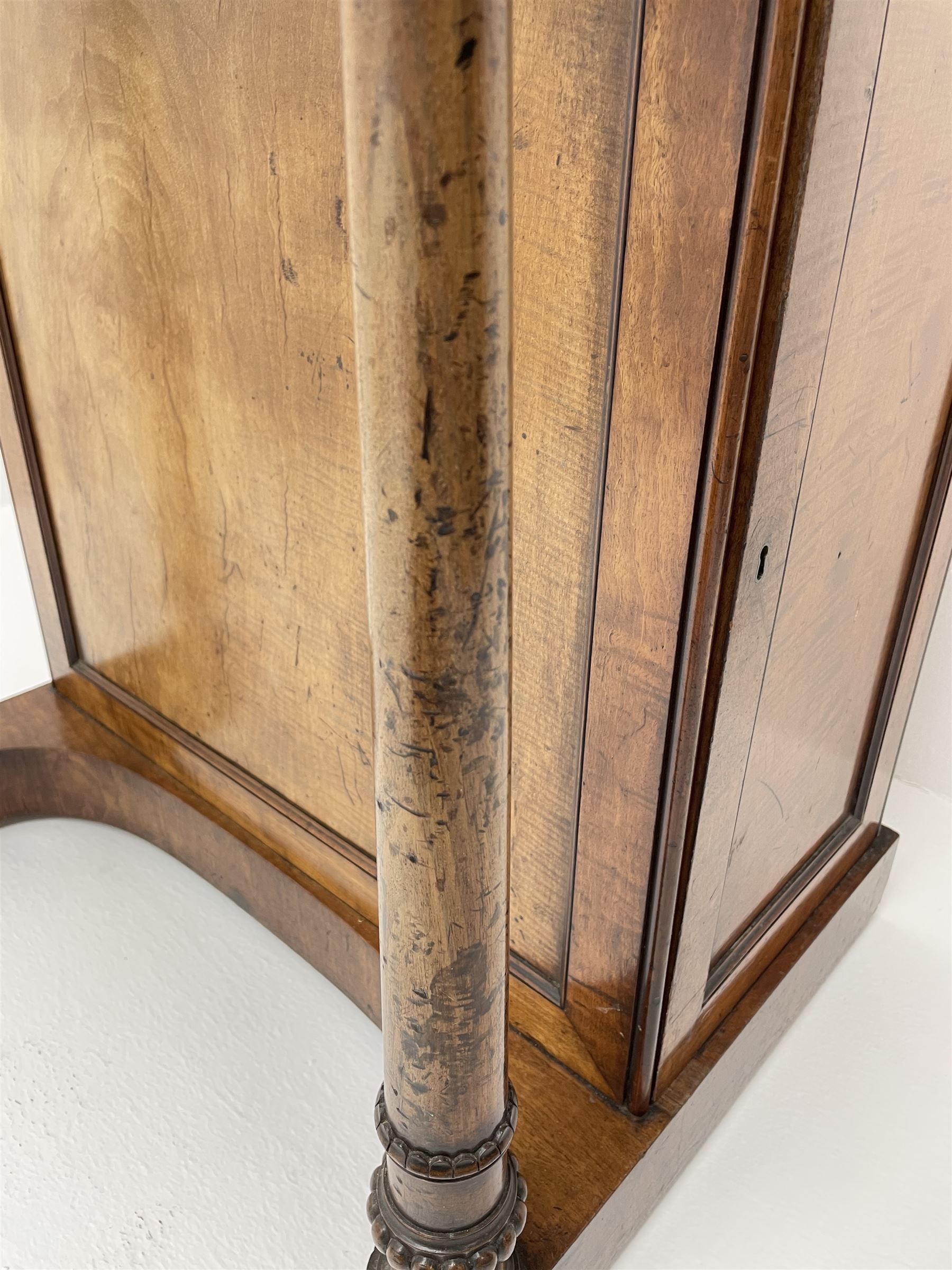 Early Victorian figured mahogany dressing cabinet, the raised shell and scroll carved back lifts to reveal rectangular easel mirror with mahogany band, flat rectangular top with tooled leather inset, slide at each side with matching leather inset, full width drawer above cupboard enclosing a series of five drawers, turned front supports, panelled front, sides and back