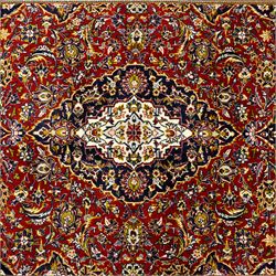 Central Persian Kashan hand-knotted carpet, crimson ground, with a central ivory shaped floral medallion with pendants, surrounded by dense scrolling foliate and floral motifs incorporating rosettes, palmettes and delicate vine work, enclosed by ivory spandrels and a dark navy border with repeating palmettes and meandering vines, flanked by floral guard stripes, with cotton fringes
