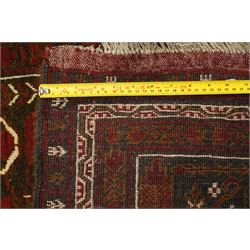 Baluchi hand-knotted prayer rug, dark brown ground divided into six panels decorated with stylised tree-of-life and flowering motifs in madder red and ivory, enclosed by multiple narrow geometric borders, with fringed ends