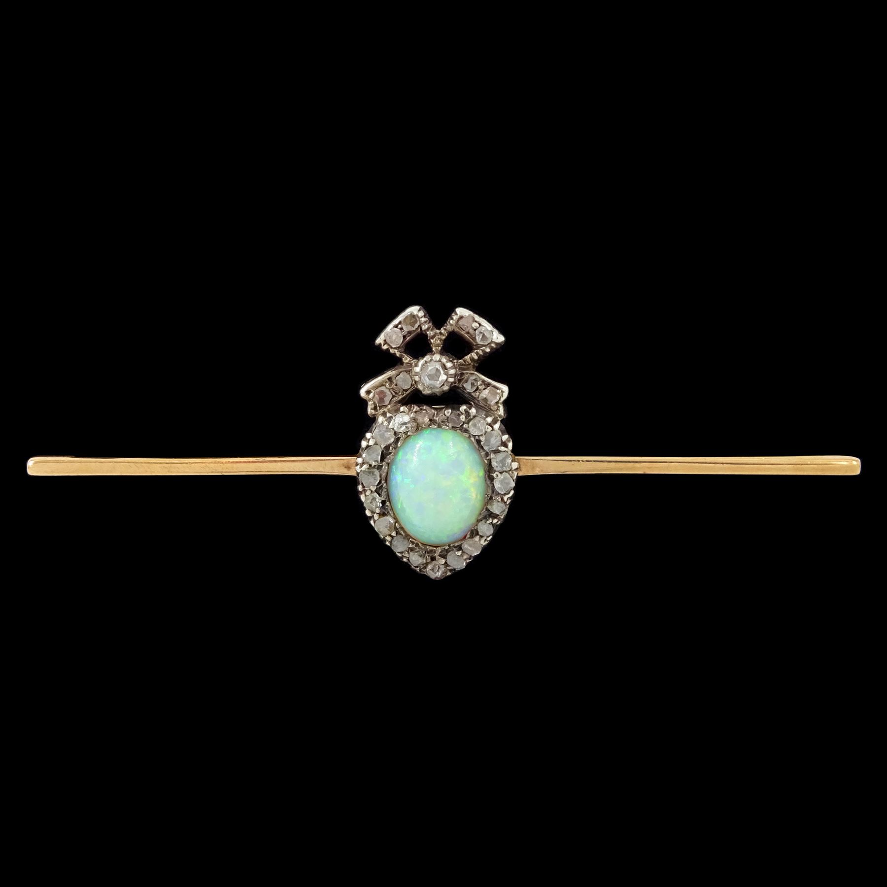 Edwardian gold and silver opal and diamond heart cluster brooch, central oval cut opal surrounded by rose cut diamonds, and surmounted by a diamond set ribbon bow