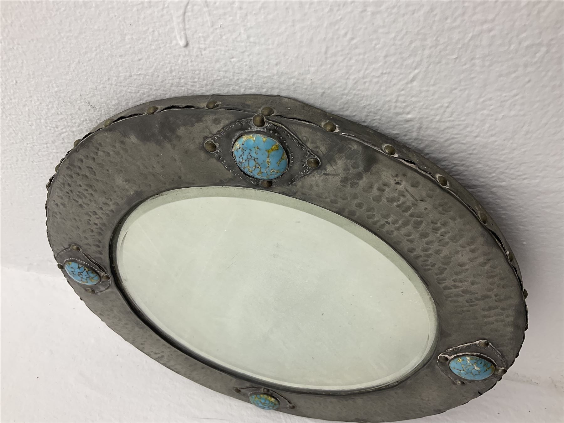 Arts & Crafts style circular hammered pewter mirror inset with four turquoise cabochons, D27.5cm