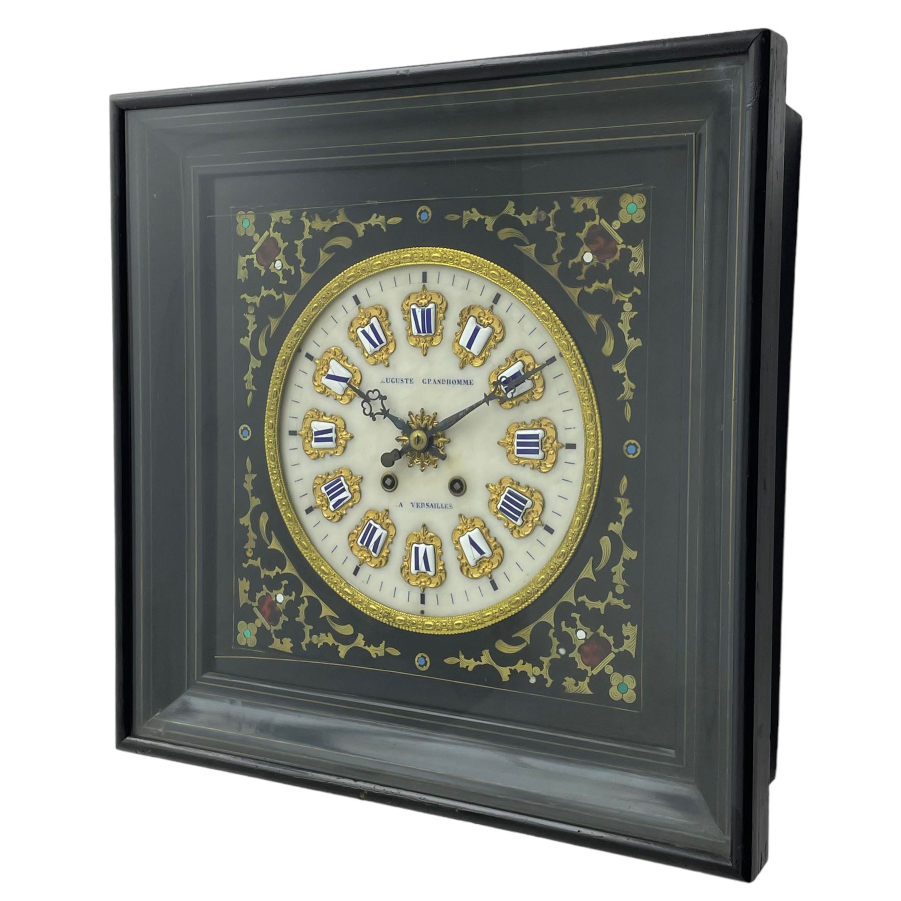 Auguste GP. Andhomme - French vineyard clock,  late 19th century 8-day twin train spring driven wall clock with enamelled and inlaid brass decoration within an ebonised and glazed case, circular enamel dial with cartouche Roman numerals, minute markers, pieced steel hands and a chased brass slip, striking movement, sounding the hours and half hours on a coiled gong. With pendulum and key.  
