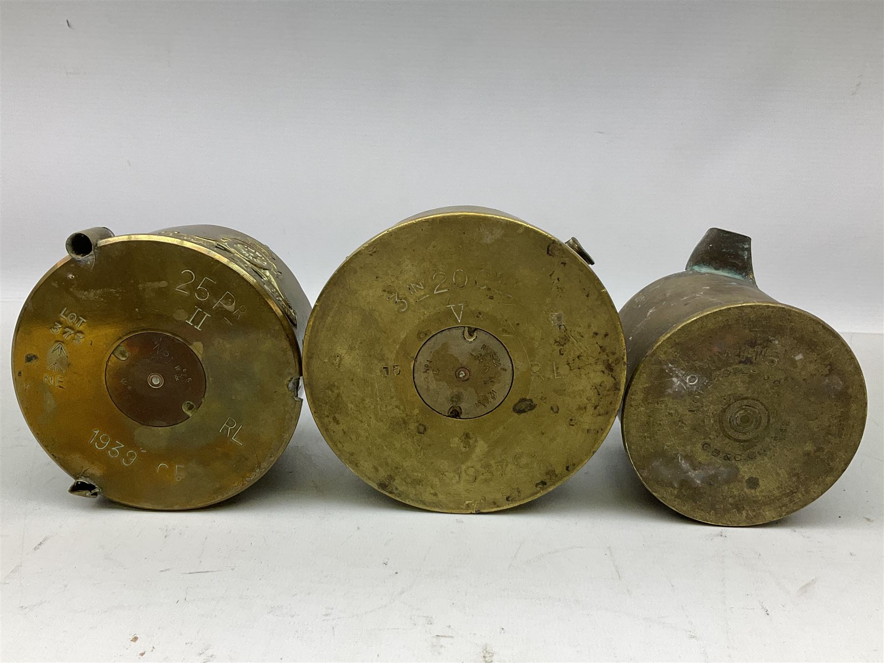 Trench Art - three WW2 brass shell case ashtrays, one mounted with Royal Artillery cap badge and button and one mounted with RA button; together with a pair of place name holders each formed from a Royal Artillery cap badge (5)
