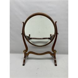 Georgian style oval dressing table mirror, the bevelled plate within an oval frame with walnut veneer  with concentric circle design and upon two bracket feet, H57cm