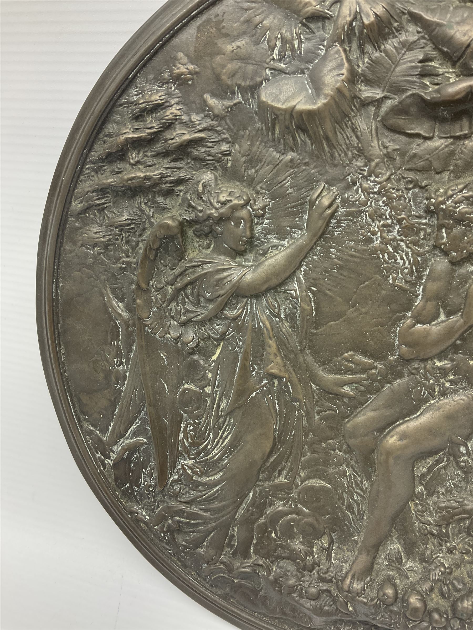 Late 19th century bronze plaque, of circular form, depicting the angel appearing to Adam and Eve in the garden of Eden in high relief, D25.5cm
