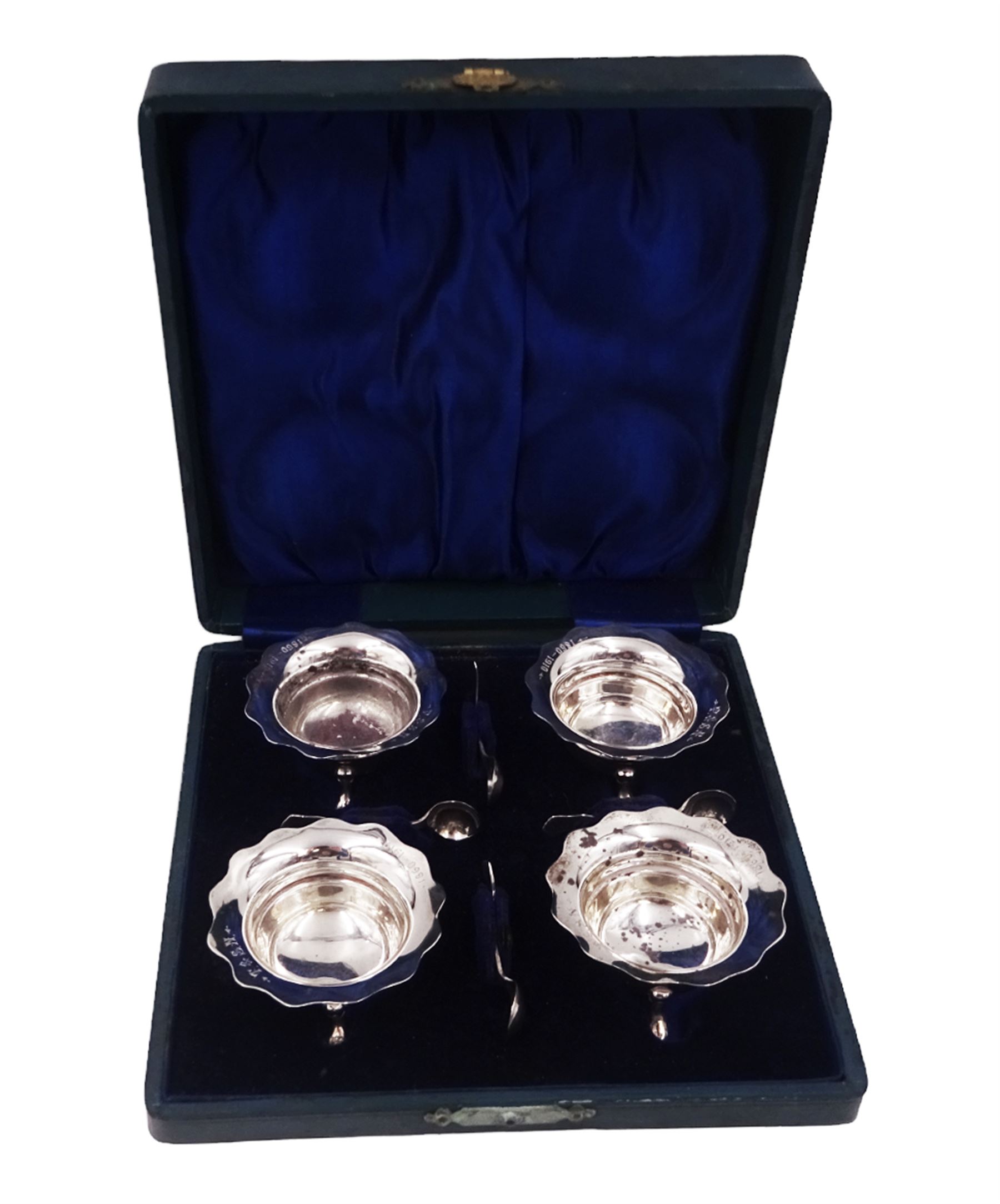 Set of four Edwardian silver open salts, of circular form, each with later personal engraving to scalloped rim and upon three pad feet, together with four matching silver salt spoons, hallmarked James Deakin & Sons, Sheffield 1909, in velvet and silk lined fitted case     