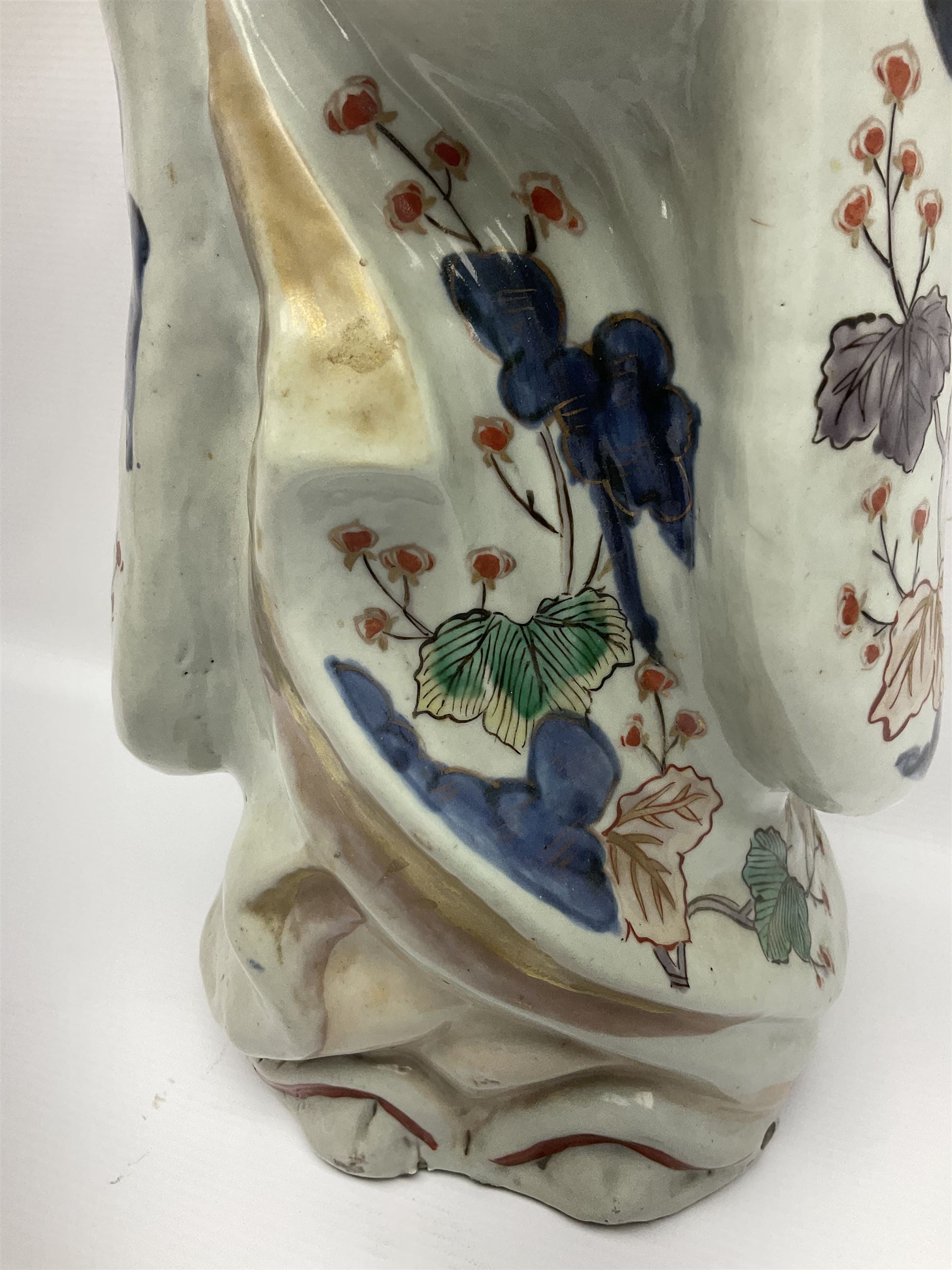 Large Japanese Imari porcelain figure, modelled as a Bijin, wearing a long kimono decorated with apple blossom and leafy branches on a white ground, with gilt detailing, possibly Edo period, H63cm