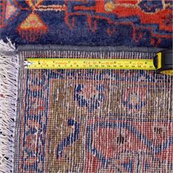 Central Persian Veis hand-knotted carpet, deep blue indigo field with central stepped lozenge medallion filled with stylized floral and geometric motifs, flanked by further angular medallions and tribal devices, edges with articulated and serrated hooked forms within a wide geometric border with repeating stylized floral motifs and multiple guard borders, in madder red, indigo blue, ivory, olive green, with cotton fringe ends