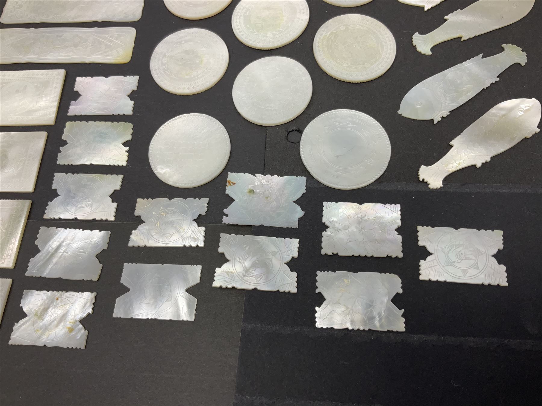 Collection of fifty seven Chinese mother of pearl gaming counters or tokens, of various size and form including rectangular, circular and fish shaped examples, various decoration including floral motifs, largest rectangular examples L6cm