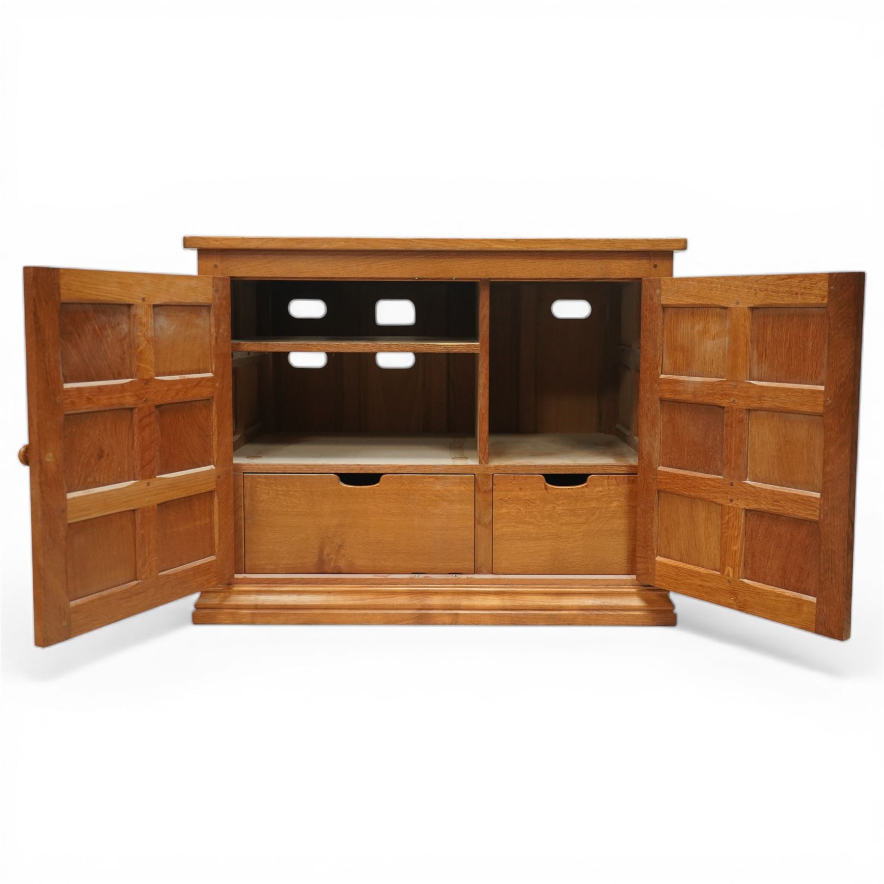  Beaverman - oak media cabinet, rectangular top with interictally carved panels to the side and front doors, twin doors with Yorkshire Rose carved wooden knob, enclosing a staggered shelf arrangement above two drawers, raised on a moulded plinth base, with carved beaver signature, by Colin Almack of Sutton near Thirsk