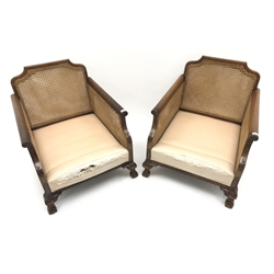  Pair early 20th century walnut Bergere armchairs, double cane work, acanthus carved cabriole legs on hairy paw feet, W75cm  