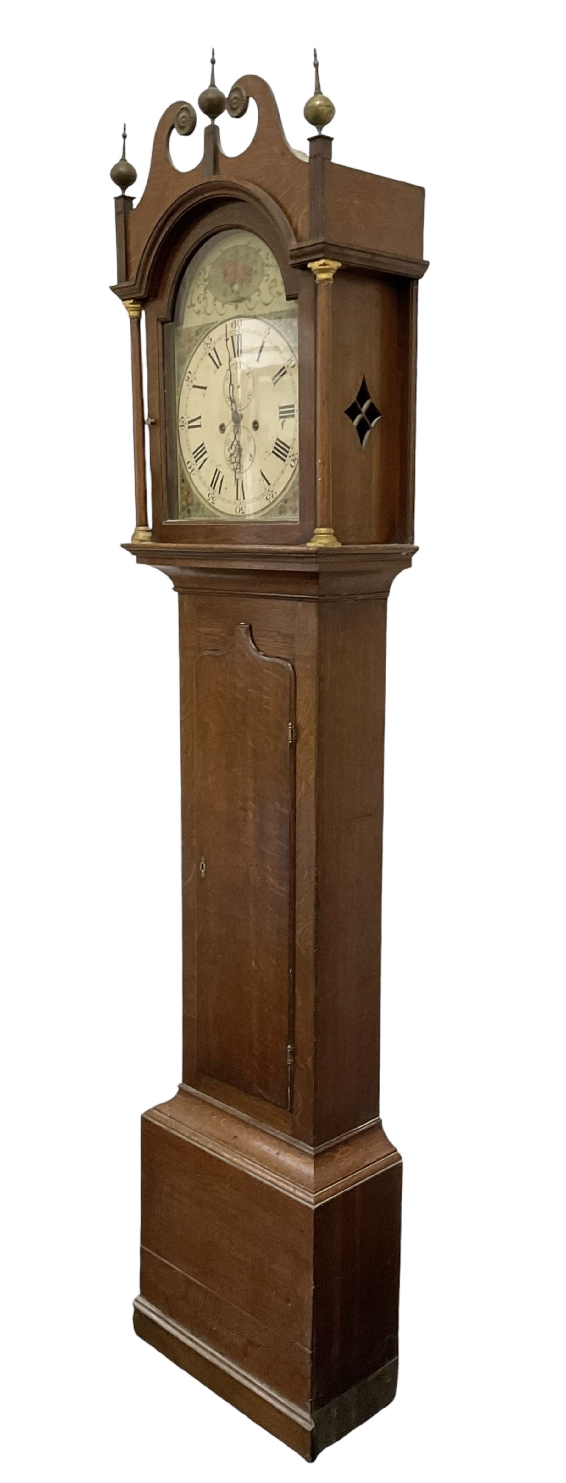 Early 19th century oak cased eight-day longcase clock c1810 - with a swan necked pediment and three matching brass finials, break arch hood door flanked by turned pilasters with brass capitals, trunk with a full length spire topped door on a square plinth with applied skirting, early painted dial with Roman numerals, Arabic five minutes, subsidiary seconds and date dials and steel hands, with floral spandrels and conforming decoration to the arch, dial pinned via a false plate to a rack striking movement, sounding the hours on a bell. With weights pendulum and key.