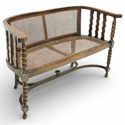 20th century bergère two seater settee, with shaped curved top rail and downswept arms, the back and seat fitted with woven cane panels, supported by turned uprights and legs united by a carolean stretcher 