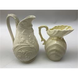 Quantity of Belleek ceramics to include mid-late 19th century jug moulded with green man mask and foliage, date code stamp for 1863-1890, together with later Belleek cornucopia shape vase, jug and other vases together with a Belleek style shell dish raised on branches, tallest H19cm
