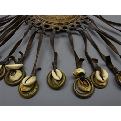 Late 19th/early 20th century African brass pouch shaped body with sliding cover decorated with shapes, hung with cowrie shells on leather straps, H19cm   